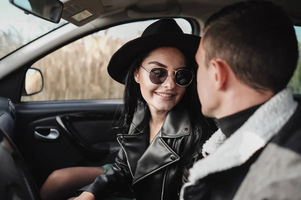 Felice coppia di viaggio vestita di nero elegante vestiti godendo di un viaggio in strada seduto all'interno della macchina, concetto di vacanza — Foto Stock