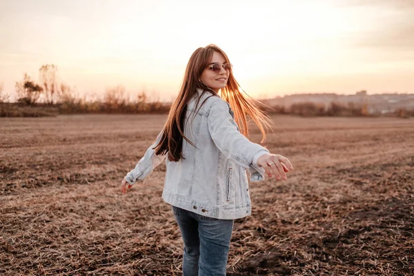 Portré Egy Gyönyörű Stílusos Lány Öltözött Farmer Kabát, Szórakozás Kívül A Város A Field Napnyugtakor — Stock Fotó