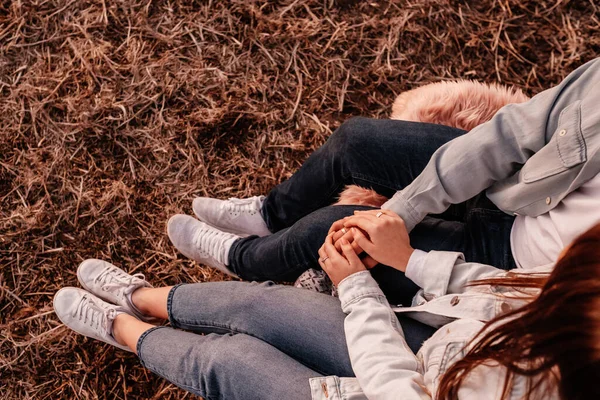 Jovem casal feliz vestido igual em camisa branca e jeans sentado em seu novo tronco de carro, belo pôr do sol no campo, férias e conceito de viagem — Fotografia de Stock