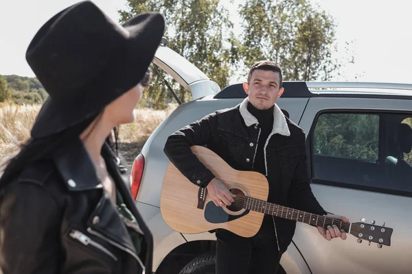 Siyah Giysili Mutlu Seyahat Çifti Saha Yolu 'nda Yolculuk, Gitar Çalan Adam, Tatil Konsepti — Stok fotoğraf