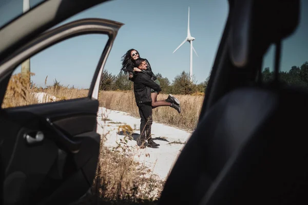 Happy Traveling Par Njuter av en bilresa på fältet väg med elektrisk vindturbin Power Generator på bakgrunden — Stockfoto
