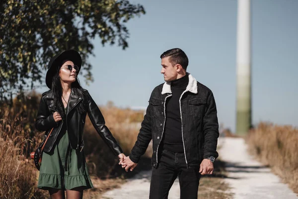 Retrato de casal feliz vestido com roupas elegantes pretas Desfrutando de um bom tempo andando em campo — Fotografia de Stock