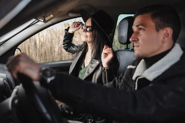 Boldog utazó pár öltözött fekete Stílusos Ruhák Élvezi a Road Trip Ül az autóban, nyaralás koncepció — Stock Fotó
