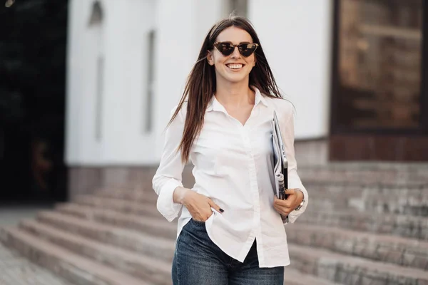Portret jednej modnej dziewczyny ubranej w dżinsy i białą koszulę z laptopem, niezależny strzelec, Business Lady, kobieta Power Concept — Zdjęcie stockowe