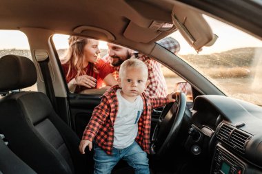 Mutlu Genç Aile Anne ve Baba Oğulları Küçük Sürücüleri Yaz Haftasonu Pikniği Şehrin dışında Sunny Day Sunset, Tatil ve Yolculuk Konsepti 'nde