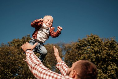 Küçük oğluyla mutlu bir baba. Yaz haftasının tadını çıkarıyor. Güneşli gün batımında şehrin dışındaki kırda.