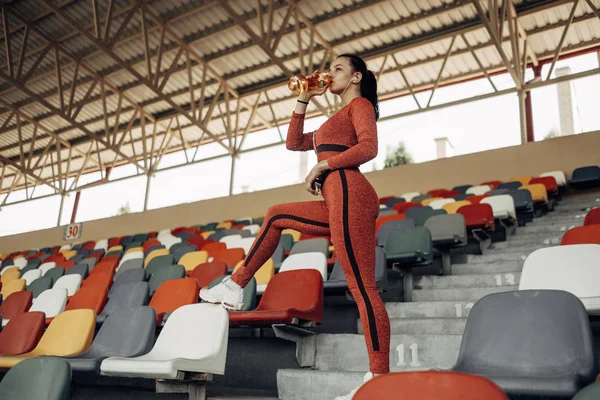 Retrato de una chica deportiva vestida con ropa deportiva haciendo ejercicio y entrenamiento en el estadio de la ciudad, concepto de estilo de vida saludable — Foto de Stock