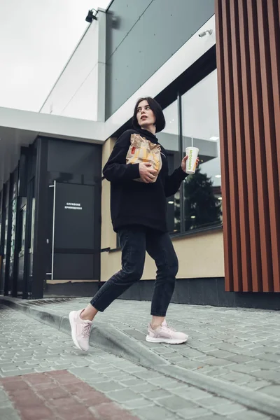 Ternopil, Ukrajna - Május 25, 2019: Stílusos lány fekete Outfit Holds csomag Fast Food Mcdonalds — Stock Fotó