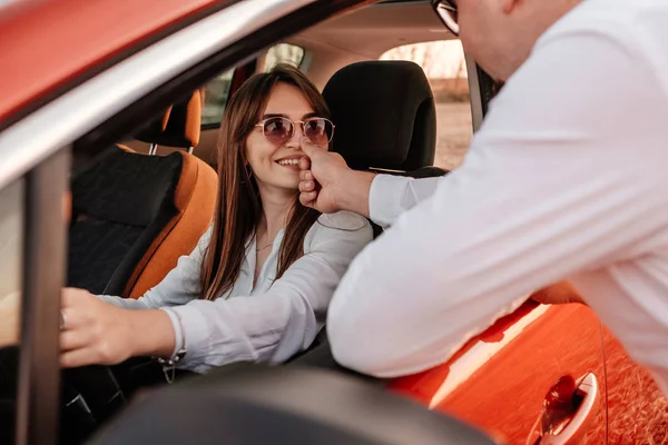 白いシャツを着た若い幸せなカップルと新しい車でロードトリップを楽しむジーンズ、フィールドでの美しい夕日、休暇と旅行のコンセプト — ストック写真