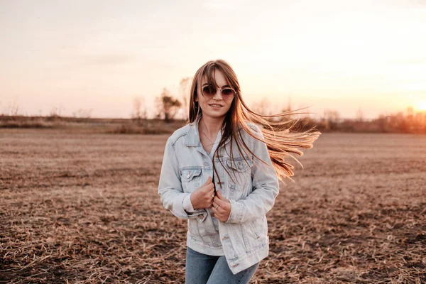 Portré Egy Gyönyörű Stílusos Lány Öltözött Fehér Ing És Jeans Jacket, Szórakozás Kívül A Város A Field Napnyugtakor — Stock Fotó