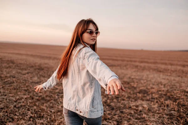 Portré Egy Gyönyörű Stílusos Lány Öltözött Farmer Kabát, Szórakozás Kívül A Város A Field Napnyugtakor — Stock Fotó