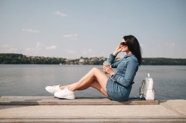 Kot pantolon giymiş güzel bir esmer kızın portresi boş zamanlarını boşa harcıyor.