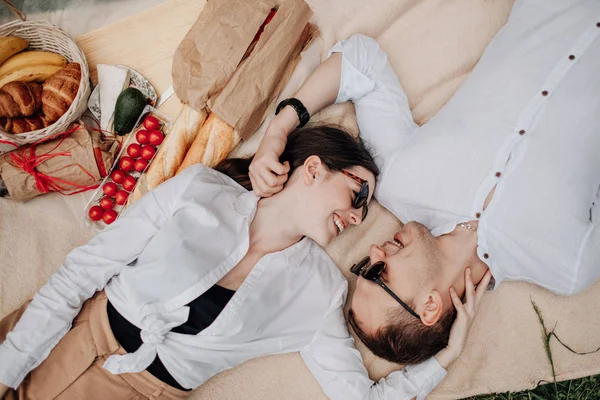 Fiatal boldog pár öltözött Alike fehér póló Szórakozás piknik, Hétvége városon kívül, Ünnepek koncepció — Stock Fotó