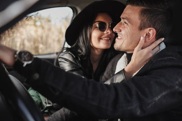 Felice coppia di viaggio vestita di nero elegante vestiti godendo di un viaggio in strada seduto all'interno della macchina, concetto di vacanza — Foto Stock