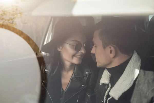 Щаслива подорожня пара одягнена в чорний стильний одяг насолоджуючись дорожньою поїздкою сидячи всередині автомобіля, концепція відпустки — стокове фото