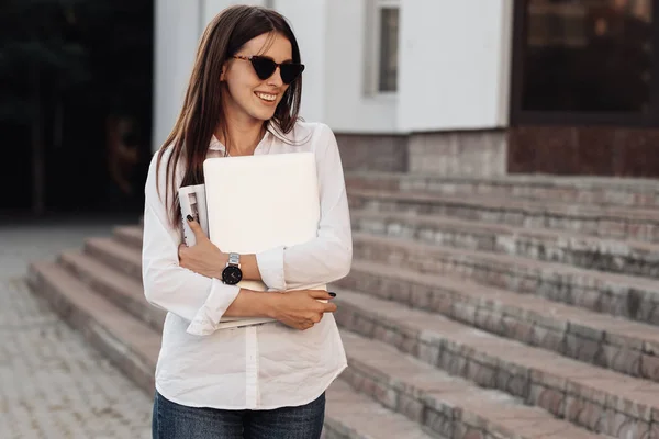 Portret jednej modnej dziewczyny ubranej w dżinsy i białą koszulę z laptopem, niezależny strzelec, Business Lady, kobieta Power Concept — Zdjęcie stockowe