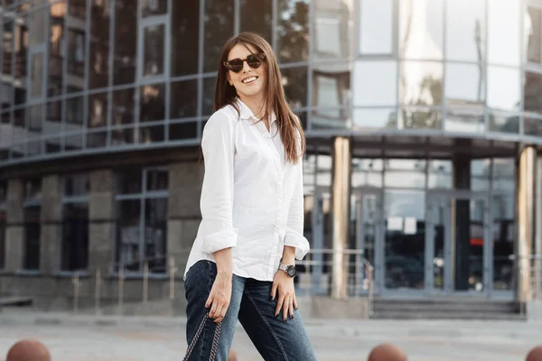 Retrato de una chica de moda vestida con vaqueros y camisa blanca, dama de negocios, concepto de poder de la mujer — Foto de Stock