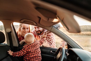 Mutlu Genç Aile Anne ve Baba Oğulları Küçük Sürücüleri Yaz Haftasonu Pikniği Şehrin dışında Sunny Day Sunset, Tatil ve Yolculuk Konsepti 'nde