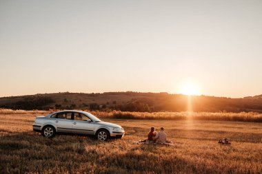 Mutlu Genç Aile Anne ve Baba ve Küçük Oğulları Hafta Sonu Keyifli Pikniği Arabayla Şehrin dışında Sunny Day Sunset, Tatil ve Yolculuk Konsepti 'nde