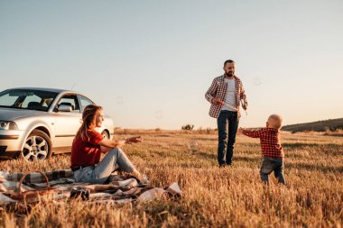 Mutlu Genç Aile Anne ve Baba ve Küçük Oğulları Yaz Haftasonu Pikniği Şehrin dışında, Baloncuklarla Oynuyor