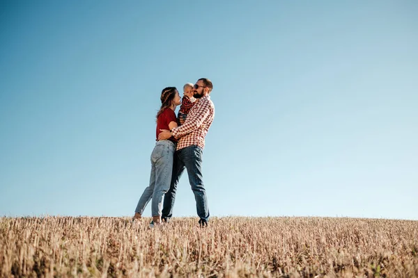 Feliz familia joven mamá y papá con su pequeño hijo disfrutando de un picnic de fin de semana fuera de la ciudad en el campo al atardecer del día soleado, concepto de tiempo de vacaciones —  Fotos de Stock