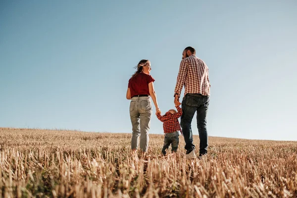 Happy Young Family Mom and Dad with Their Little Son Enjoying Summer Weekend Picnic Outside the City in the Field at Sunny Day Sunset, Vacation Time Concept — Stock Photo, Image