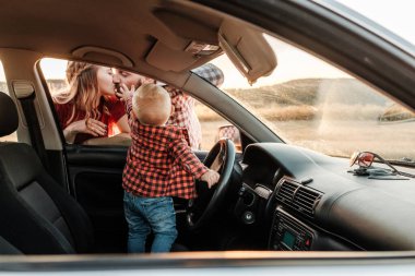 Mutlu Genç Aile Anne ve Baba Oğulları Küçük Sürücüleri Yaz Haftasonu Pikniği Şehrin dışında Sunny Day Sunset, Tatil ve Yolculuk Konsepti 'nde