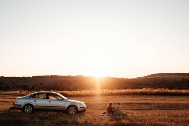Mutlu Genç Aile Anne ve Baba ve Küçük Oğulları Hafta Sonu Keyifli Pikniği Arabayla Şehrin dışında Sunny Day Sunset, Tatil ve Yolculuk Konsepti 'nde