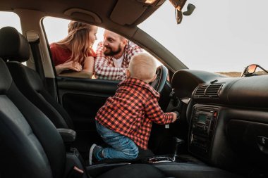Mutlu Genç Aile Anne ve Baba Oğulları Küçük Sürücüleri Yaz Haftasonu Pikniği Şehrin dışında Sunny Day Sunset, Tatil ve Yolculuk Konsepti 'nde