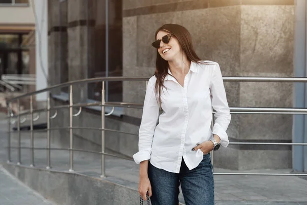 Retrato de una chica de moda vestida con vaqueros y camisa blanca, dama de negocios, concepto de poder de la mujer — Foto de Stock