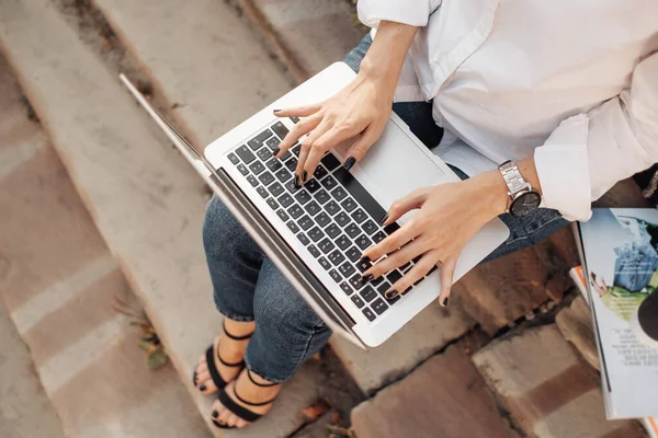 Портрет одной модной девушки, одетой в джинсы и белую рубашку, работающей на ноутбуке, внештатный работник, бизнес-леди, женщина концепции власти — стоковое фото