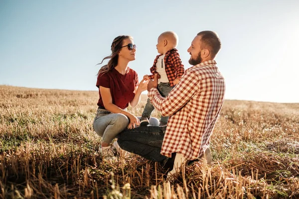 Happy Young Family Mom and Dad with Their Little Son Enjoying Summer Weekend Picnic Outside the City in the Field at Sunny Day Sunset, Vacation Time Concept — Stock Photo, Image