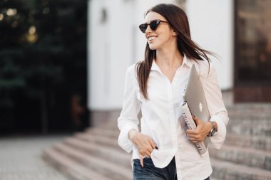 Ternopil, Ukrayna - 28 Ağustos 2019: kot pantolon ve beyaz gömlekli bir kızın portresi Macbook Air, Freelance Worker, Business Lady, Woman Power Concept