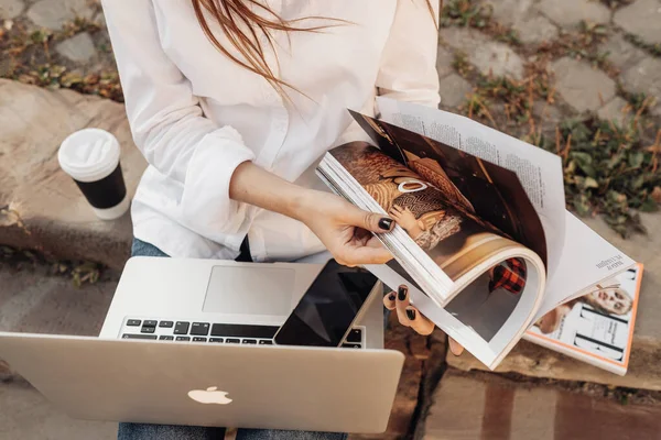 TERNOPIL, UCRANIA - 28 de agosto de 2019: Chica de moda vestida con pantalones vaqueros y camisa blanca Trabajando en Apple Laptop Macbook Air, Trabajador independiente, Business Lady —  Fotos de Stock