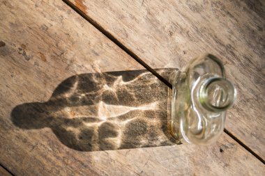 Cam şişe ve ahşap arka plan, seçici odak yansıması