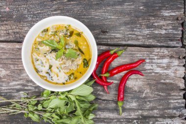 Tay tavuk yeşil köri ile eski ahşap arka plan