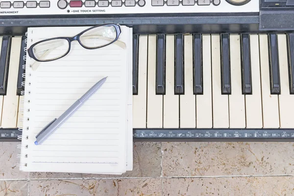 Livro de notas com óculos no teclado — Fotografia de Stock