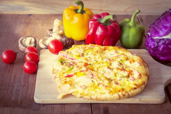 Deliciosa pizza fresca na mesa de madeira — Fotografia de Stock