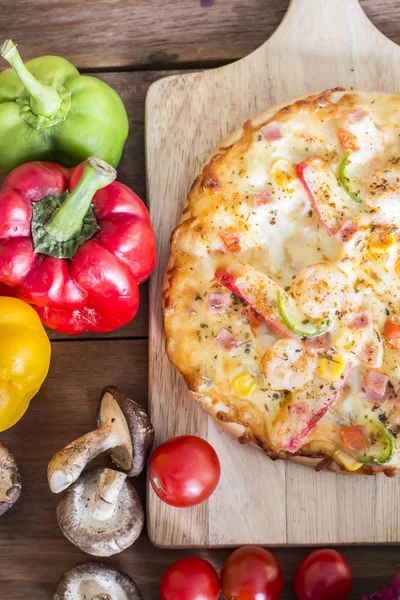 Pizza e vergetables em fundo de madeira — Fotografia de Stock