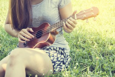 Genç kadın ukulele üzerinde oynama