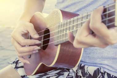 Genç kadın ukulele üzerinde oynama 