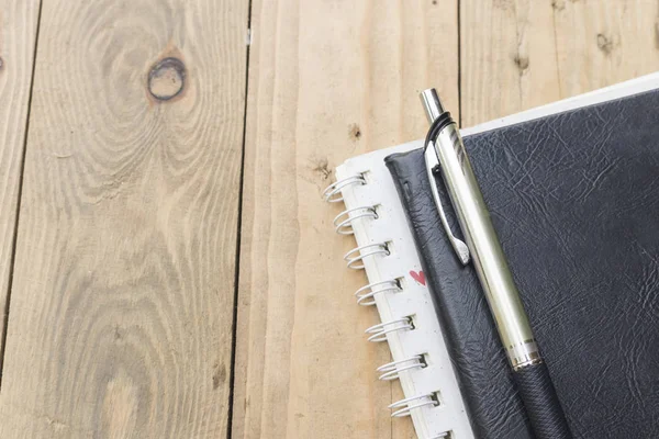 defter ve kalem masanın üstünde.