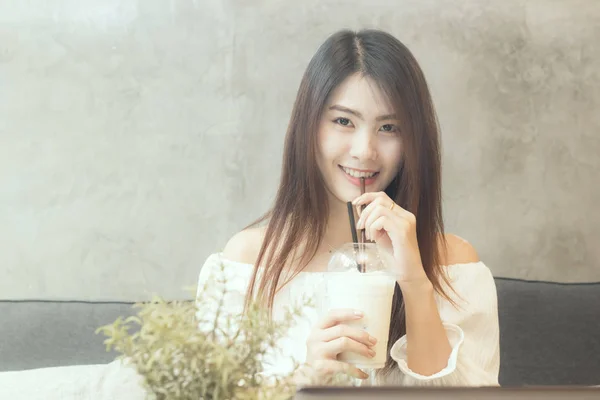Asyalı kadın buzlu kahve içiyor.