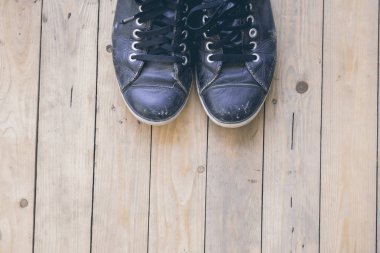 Ahşap güverte üzerinde spor ayakkabı