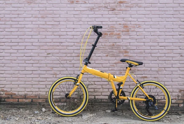 レンガの壁に黄色の自転車 — ストック写真
