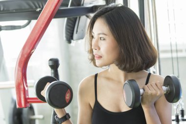 Asyalı genç kadın dumbbell ile