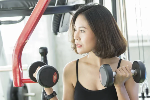 Asyalı genç kadın dumbbell ile