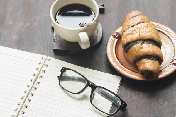 Kaffekopp, Glasögon, notera bokar, croissant — Stockfoto