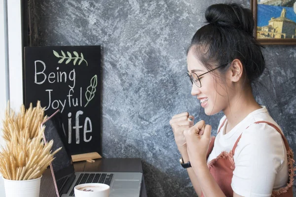 Young asian women winning watching a laptop