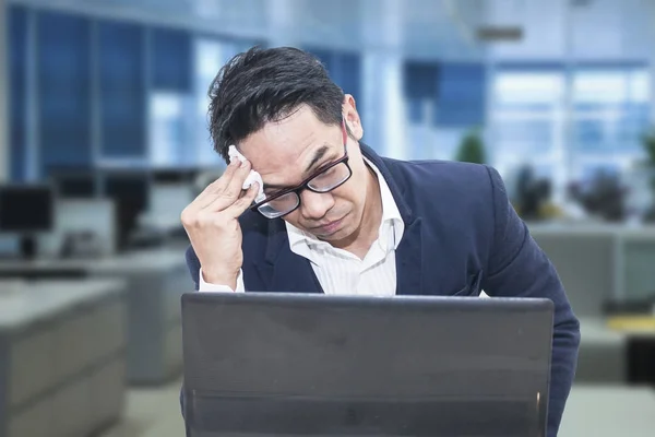 Втомився бізнесмен в окулярах, витираючи лоб — стокове фото